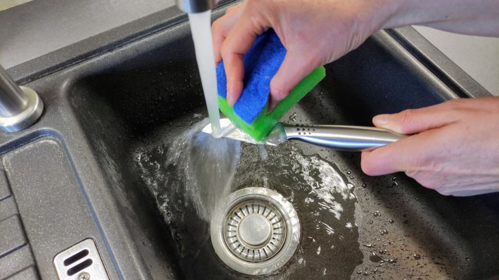 Küchenmesser von Hand unter fließendem Wasser reinigen